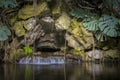 tropical garden pond with waterfall and rock wall Royalty Free Stock Photo