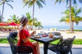 Tropical healthy breakfast in hotel with sandy sea beach, palm trees and swing Royalty Free Stock Photo