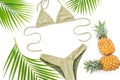 Tropical holiday concept with pineapple, palm leaves and bikini swimwear on white background. Flat lay