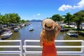 Tropical Holidays. Beautiful woman holding hat enjoying tropical landscape