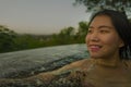 Tropical holidays lifestyle portrait of young beautiful and happy Asian Korean woman in bikini enjoying sunset at amazing jungle