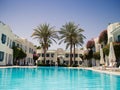 Tropical hotel with pool and palm trees. Summer vacation Rest at hotel resort. Palm trees near Large blue outdoor