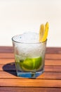 Tropical icy cocktail with fruits on the wooden table at the beach