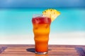Tropical icy cocktail with pineapple on the wooden table at the beach and ocean Royalty Free Stock Photo