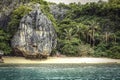 Tropical island beach landscape cliff rock and palm trees and turquoise sea Royalty Free Stock Photo