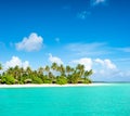 Tropical island beach with palm trees and cloudy blue sky Royalty Free Stock Photo