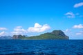 Tropical island in blue sea. Green land in blue seascape. Philippines travel photo. Abandoned island seaside view