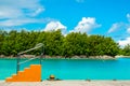 Tropical island jetty with orange boarding ladder and aquamarine