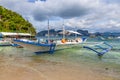 Tropical island landscape with bangca traditional philippines boats anchored at the shore, Palawan