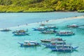 Tropical island landscape with lots of bangca traditional philippines boats anchored at the shore full of tourists, Vigan Island,