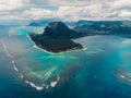 Tropical island with Le Morne mountain, blue ocean and underwater waterfall in Mauritius. Aerial view