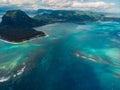 Tropical island with Le Morne mountain, ocean and underwater waterfall in Mauritius. Aerial drone view