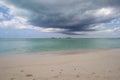 Tropical island off the coast of a sandy beach on a cloudy day Royalty Free Stock Photo