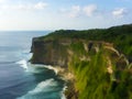 Tropical island`s cliff coast and oceanic wave. Uluwatu temple of Bali, Indonesia Royalty Free Stock Photo