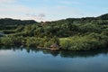 Tropical island view from the deck of cruise ship. Roatan island in Honduras with green trees in jungle woods and small wooden hut Royalty Free Stock Photo