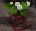 Tropical jasmine flower and Bell red Bow on wood. Jasmine flowers
