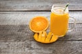 Tropical juice of mango, orange, banans fruit in jar with straw on wooden board. Royalty Free Stock Photo