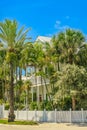 Tropical Key West two story white house with balcony behind picket fence with tall palm trees beneath a turquoise sky Royalty Free Stock Photo