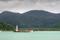 Tropical landscape with turquoise tropical sea, white lighthouse, fishing boat, Bang Bao pier and Koh Chang island on horizon Royalty Free Stock Photo