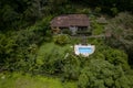 Tropical mountainous building with a swimming pool in a garden seen from above in Brazil