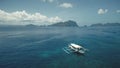 Tropical ocean aerial: boats, ships, yachts at blue water. Serene sea bay at island cliff shore