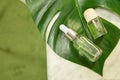 Tropical palm leaves on a marble background. Essential oil in a glass bottle. Spa concept for natural cosmetics and skin Royalty Free Stock Photo