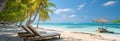 A tropical paradise: Beach, lounge chairs, palm trees, and calm azure sea Royalty Free Stock Photo