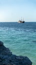 Tropical paradise, Caribbean sea. View of bright blue ocean with old vintage ship, rocky shore