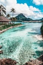 Tropical paradise with turquoise waters, palm trees, and mountains. Bora Bora, French Polynesia