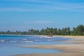 Tropical Pasikuda beach with golden sand and palm trees on the island of Sri Lanka. Turquoise sea with a low tide