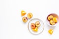 Tropical peach and orange fruits for fresh juice on plates white background top view space for text