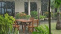 Tropical rain drops falling on the green palm tree leaves and wooden table in island Koh Samui Royalty Free Stock Photo