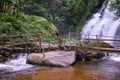 Tropical rain forest landscape with jungle plants, flowing water of Pha Dok Xu waterfall and bamboo bridge. Mae Klang Luang Royalty Free Stock Photo