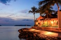 Tropical resort with a blue sea and palm trees at night. Royalty Free Stock Photo