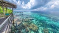 Tropical resort wooden walkway to overwater bungalows over turquoise ocean water