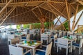 Tropical restaurant with wooden tables and chairs at luxury five stars resort Royalty Free Stock Photo