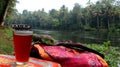 Tropical river journey with red drink and vibrant fabric Royalty Free Stock Photo