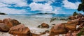 Tropical rockbound panorama landscape with white fluffy clouds above Praslin island. Anse Severe beach on La Digue