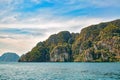Tropical rocky island in the Andaman Sea. Near Phi Phi Island. Calm blue water and slightly cloudy sky Royalty Free Stock Photo