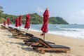 Tropical sand beach with wooden deck chairs and umbrellas near sea on a sunny day. Nature concept. Thailand Royalty Free Stock Photo