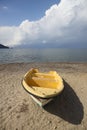 Tropical Seascape with a boat on sandy beach at cloudy sunrise or sunset Royalty Free Stock Photo