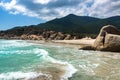 Tropical Seascape with A Wild Beach, Turquoise Water, Rocks, Mountains and Clouds in The Blue Sky