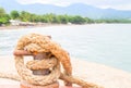 Tropical seaside landscape. Pier rope holder with rustic tackle closeup.