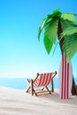 Tropical still life. Dawn on the sandy coast with palm trees. A chaise longue and a surfboard on the beach Royalty Free Stock Photo