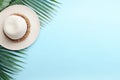 Tropical Summer Composition with Palm Leaves, Hat, and Coconut on Pastel Blue Background AI Generated Royalty Free Stock Photo