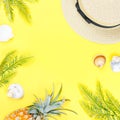 Tropical summer concept with woman fashion accessories, leaves and pineapple on yellow background. Flat lay, top view Royalty Free Stock Photo