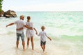 Tropical summer vacations. Happy family having fun together on the beach. Father, mother, son holding hands Royalty Free Stock Photo
