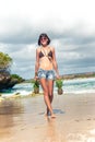 Tropical summer woman with pineapple walking on the beach. Outdoors, ocean, nature. Bali island paradise.