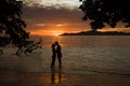 Tropical sunset, ocean shore with silhouette of a lover couple