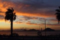 Tropical sunset with palm trees and sea. Silhouettes of palm trees on the beach against the sky with clouds. Royalty Free Stock Photo